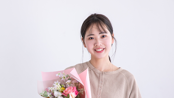 誕生日のプレゼントを抱えている介護士の写真